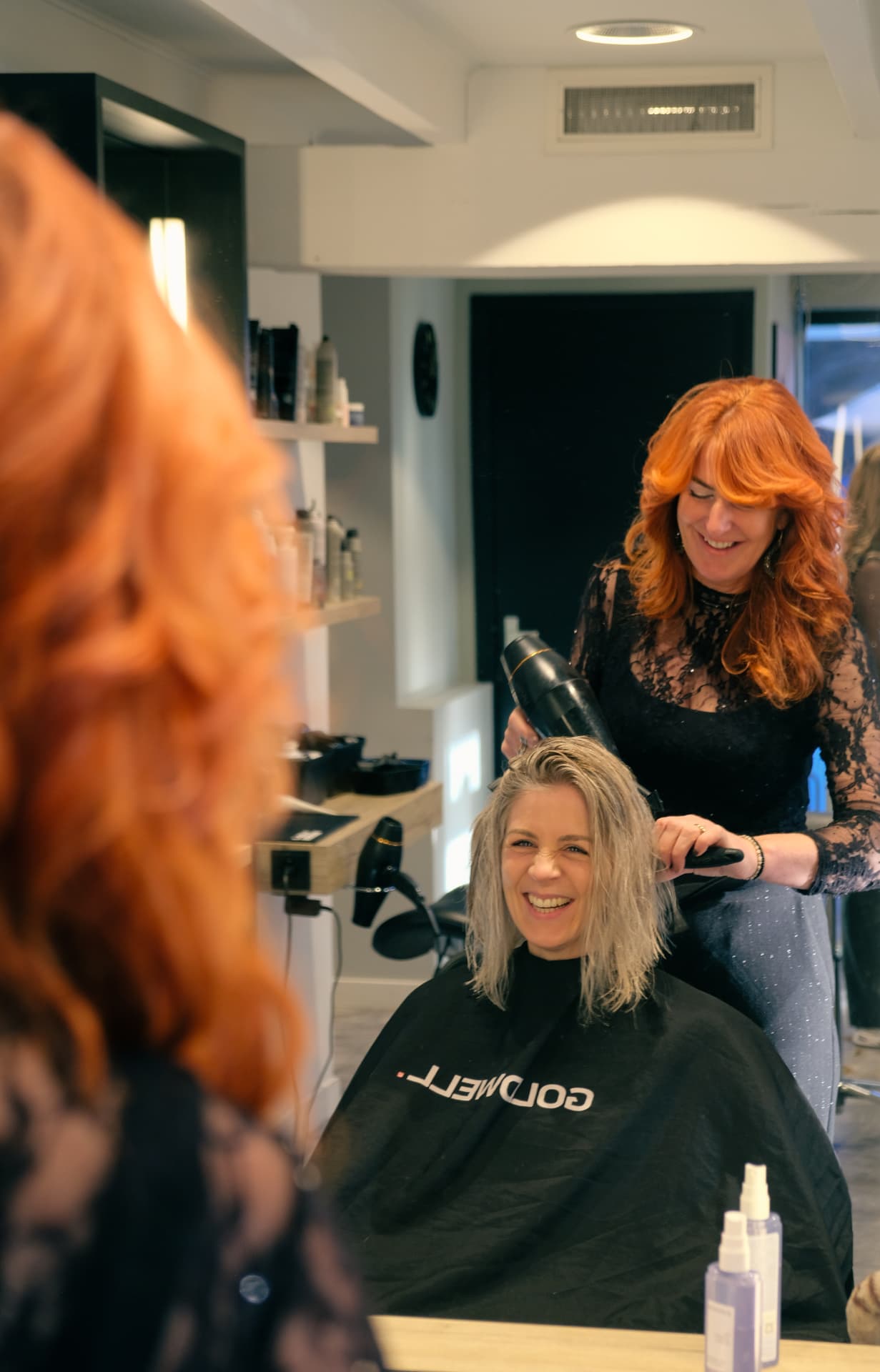 Mariël in gesprek en aan het werk met een klant in de salon